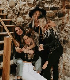 four women are posing for a photo on the stairs