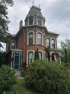 a large brick house with a clock on the top of it's steeple