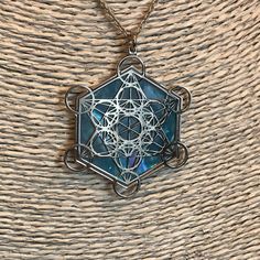 "Metatron in 925 silver and blue mother of pearl backdrop. The cube known as Metatron takes name by the same Archangel, known as God's scribe. It contains every shape that exists in the universe God has created combining male and female aspects. Within the cube thirteen spheres of female eneregy lies drawing the Fruit of Life, in the middle of which male straight lines are irradiated. In its shapes a triangle and two cubes are also created by six line started from the middle. It also contains al Spiritual Blue Medallion Necklaces, Blue Medallion Spiritual Necklaces, Blue Medallion Necklace For Spiritual Style, Spiritual Square Pendant Jewelry, Blue Star Of David Necklace As Gift, Blue Star Of David Necklace Gift, Blue Star Of David Necklace For Gift, Spiritual Silver Necklaces For Meditation, Spiritual Silver Square Pendant Jewelry