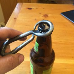 a bottle opener being used to open a beer