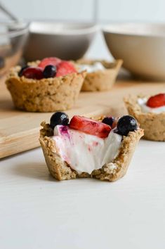 mini cheesecakes with berries and whipped cream on top are ready to be eaten