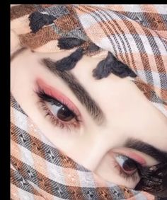 a close up of a person with long lashes and eyeliners covering her face