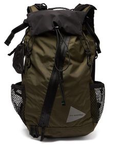 a green backpack with black straps and mesh pocket on the front, sitting against a white background