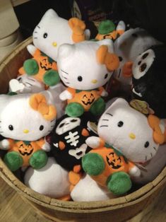 many hello kitty stuffed animals in a wooden bowl with pumpkins and jack - o'- lanterns