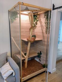 a living room with a couch and a tree in the corner that is made out of wood