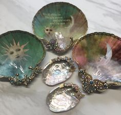 four seashells with pictures on them sitting on a marble counter top in front of a quote