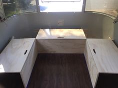 the inside of a camper with two benches and a table in it's center