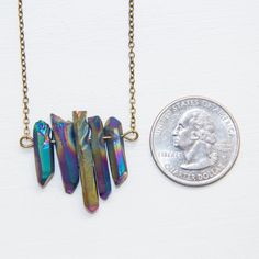 "Eye-catching as a solitary piece or layered, this rainbow family sparkles in a kaleidoscope of dramatic deep blue, violet and golden metallic sheen. Associated with optimism, hope, joy, healing, insight, illumination * Crystal pendant: approximately 1\"H x 1.25\"W * Chain length (measured end-to-end): about 20 inches All chain and findings are nickel-free and each piece is individually packaged in an organic cotton jewelry pouch that doubles as a polishing cloth. A paper receipt will not be inc Rainbow Crystal Necklace With Natural Stones, Rainbow Crystal Necklace, Spiritual Rainbow Gemstone Necklace, Spiritual Rainbow Crystal Gemstone Necklaces, Rainbow Gemstone Pendant Necklace, Rainbow Family, Cotton Jewelry, Titanium Quartz, Rainbow Quartz