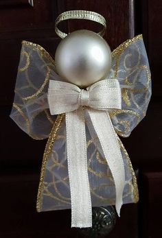 an ornament with a white bow and a pearl on it's side