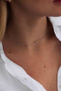 This delicate Fine Beaded chain in Sterling Silver is perfect for holding your favourite pendant charms, or wearing alone for a chic look.  Addictively smooth to the touch, this chain necklace also known as a Bobble chain, features a strand of pretty 2mm round mirror-polished ball beads which have been interspersed at intervals along the 2 cm Trace chain.  Details: - Solid Sterling Silver - Rhodium Plated - ADJUSTABLE LENGTH FEATURE. The length of this silver choker necklace can be adjusted from Silver Ball Necklace, Simple Choker, Crystal Stone Jewelry, Dainty Chain Necklace, Dot Necklace, Silver Choker Necklace, Silver Choker, Ball Necklace, Crystal Choker