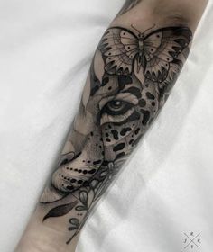 a black and white tattoo on the arm of a person with a butterfly in it