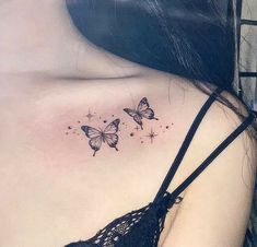 a woman's chest with three butterflies on the left side of her body and stars in the middle