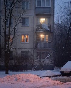 an apartment building at night with snow on the ground