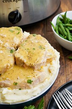 a plate with mashed potatoes and green beans next to an instant pot roaster