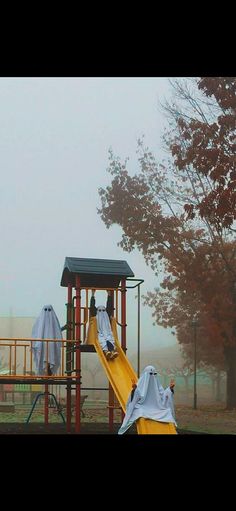 a yellow slide in the middle of a park