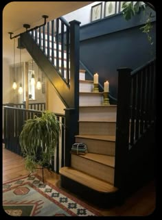 a stair case next to a potted plant in front of a staircase with candles on it