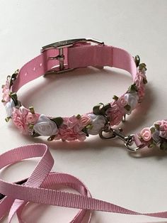 two pink leashes with flowers on them sitting next to each other