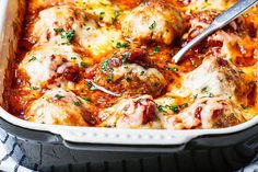 a casserole dish filled with meatballs and sauce, garnished with parsley