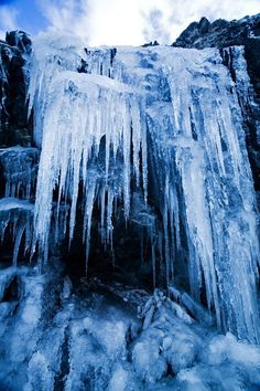 icicles are hanging from the side of a mountain