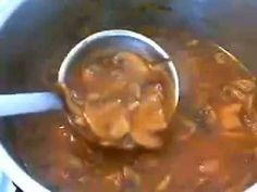 a ladle full of soup being stirred by a spoon