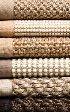 a stack of different colored rugs on top of each other in various sizes and colors