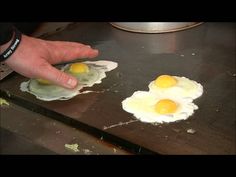 two fried eggs are being made on a pan