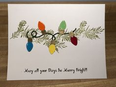 a christmas card with pine branches and lights on it that says, may all your days be merry bright