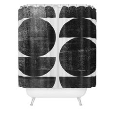 a black and white shower curtain with circles on the bottom, in front of a white background