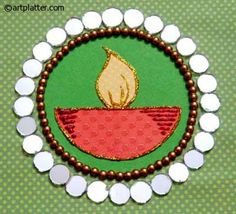 an embroidered brooch with a red bowl and a yellow flame in the center surrounded by white circles