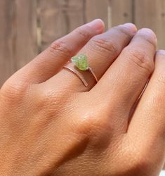 💚Raw and natural tiny peridot stone in adjustable dainty 18g gold or silver ring band with hand hammered ends. Perfect dainty little ring that can fit any fingers of your choice. 💚Peridot - An August birthstone. This gift from the heart of Mother Nature comes with a ton of healing properties. Deep-set calm, good health, restful slumbering, and restoring balance and harmony to the body, mind and soul are just a handful of things you can expect when you say yes to Peridot. Ring size- Fits 5-8 ad Minimalist Crystal Ring For Healing, Minimalist Natural Stones Open Ring Jewelry, Minimalist Gemstone Rings For Healing, Minimalist Healing Gemstone Rings, Green Peridot Stackable Rings, Green Gemstone Stackable Rings For May Birthstone, Green Peridot Stackable Jewelry, Stackable Green Peridot Jewelry, Adjustable Delicate May Birthstone Jewelry