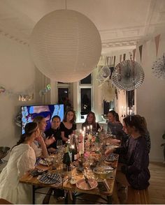 a group of people sitting around a table with food