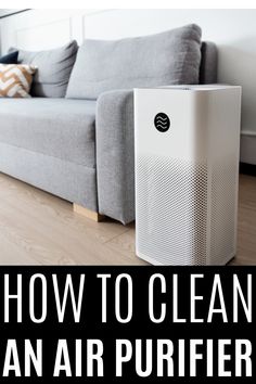 an air purifier sitting on the floor in front of a couch