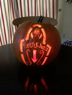 a carved pumpkin with the words beetlejuice on it's front and side