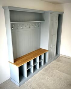 an empty room with some shelves and wine glasses on the top shelf, next to a tiled floor