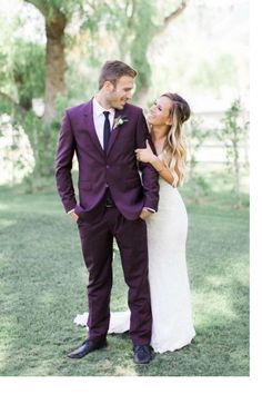 a bride and groom standing in the grass