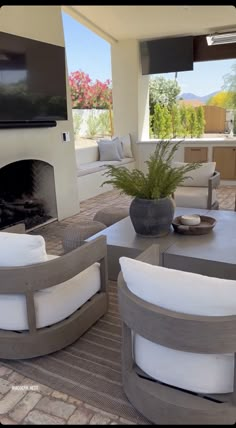 a living room filled with furniture and a flat screen tv mounted on the wall over a fire place