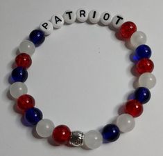 Red Sparkle, White-glow and Blue beads in an elastic bracelet with a silver spacer bead. Fits up to a 7.5 inch wrist. The white-glow plastic beads are fishing lures. The red and blue beads are glass. Letter beads are white plastic. The glow beads may glow-in-the-dark after exposure to UV light. Length of the "glow" depends on the time exposed to UV light, and is not guaranteed. Red White And Blue Beaded Bracelet, Patriotic White Stretch Bracelet With Round Beads, Patriotic White Stretch Bracelet, Patriotic White Jewelry With Colorful Beads, Adjustable White Bracelet For 4th Of July, Adjustable White Patriotic Beaded Bracelets, Patriotic White Stretch Bracelet As Gift, Patriotic White Stretch Bracelet Gift, Adjustable White Beaded Bracelets For 4th Of July