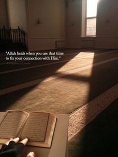 an open book sitting on top of a carpeted floor in front of a window