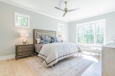 a bedroom with a bed, dresser and ceiling fan in it's center area