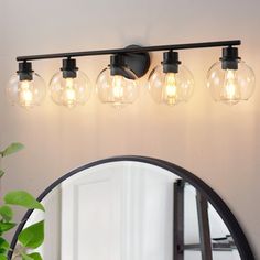 a bathroom vanity light with three bulbs on it and a mirror in the corner next to it