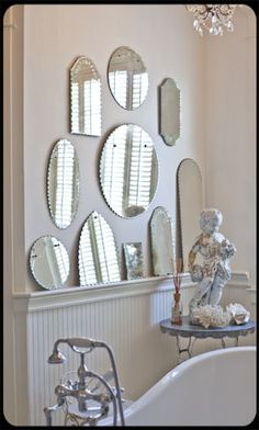 a bath room with a tub and mirrors on the wall