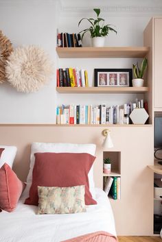 a bedroom with bookshelves and shelves above the bed