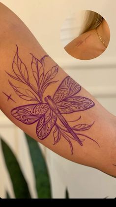 a woman's arm with a dragonfly tattoo on it and a plant in the background