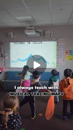 several children are standing in front of a projector screen with the words, i always teach with musical tracking maps