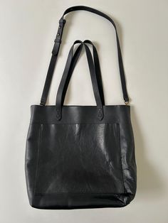 | Description |  Modern Madewell medium Transport black leather tote bag.  Leather has a nice hand.  Tote has exterior open pocket, interior zip pocket and is unlined.  Tote is in excellent condition with light surface wear.  Interior pocket is marked "Madewell".   | Approximate Size | tote:  11" W x 5 1/2" D x 12 1/4" H | Disclaimer | Please read the description and review photos thoroughly, as all sales are final.  Please read shop policies for full details.  Please message me with any additional questions.  All items are used/vintage and have wear consistent with age. Black Leather Tote Bag, Black Leather Tote, Tote Bag Leather, Phoenix Az, Shop Policies, Leather Tote Bag, 4 H, Leather Tote, Halloween Shopping