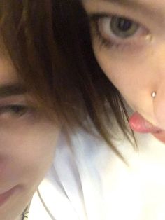 two people with piercings on their nose looking at the camera