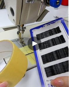 a person is using a sewing machine to sew on some black and white tape