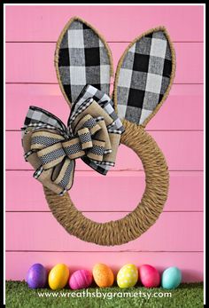 an easter bunny wreath hanging on the side of a pink wall