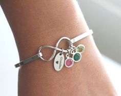 The personalized infinity bangle with Grandma - Nana - Mimi - Grammy - Grammie charm and birthstones makes a beautiful gift for grandmothers.Available oval charm inscriptions (shown in picture #2)- Grandma ❤- Nana ❤- Mimi ❤- Grammy ❤- Grammie ❤★ We're sorry, we are not able change the text on the charms or to hand stamp on the back of the charmsCOMPONENTS❤ small Swarovski crystal birthstones - please specify the months for the birthstones in the personalization box. Please note that the stone fo Adjustable Infinity Stainless Steel Jewelry, Friendship Infinity Metal Jewelry, Metal Infinity Jewelry As Friendship Gift, Infinity Metal Jewelry For Friendship, Metal Infinity Jewelry For Friendship, Personalized Infinity Metal Jewelry, Personalized Adjustable Infinity Jewelry, Personalized Infinity Bracelets For Friendship, Adjustable Infinity Bracelet For Personalized Gift