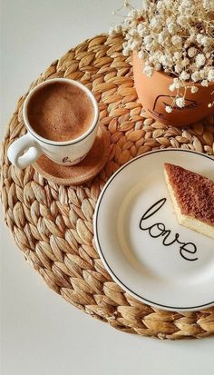 a piece of cake sitting on top of a plate next to a cup of coffee